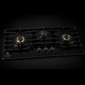 Benson Flame Supreme 3 Burner Built-in Hob displayed in a premium black studio with black tempered glass, three brass burners, cast iron pan supports, and burners switched off.